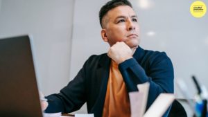 Man sitting with laptop deep in thought