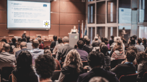 woman presenting to audience on lectern