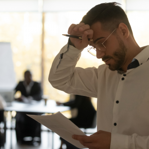 man looking nervous holding paper