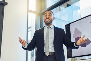 Shot of a young businessman enthusiastically delivering a presentation in the boardroom of a modern office