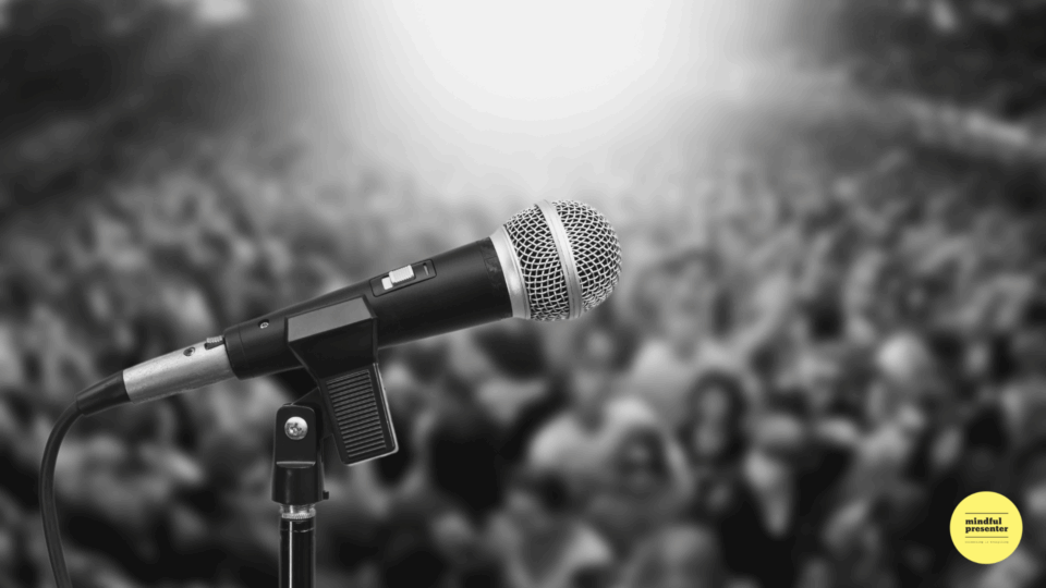 black and white photo of microphone and blurred audience