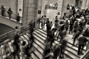 black and white image of people walking on stairs