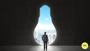 Man standing in front of an opening in the shape of a giant light bulb looking at the city