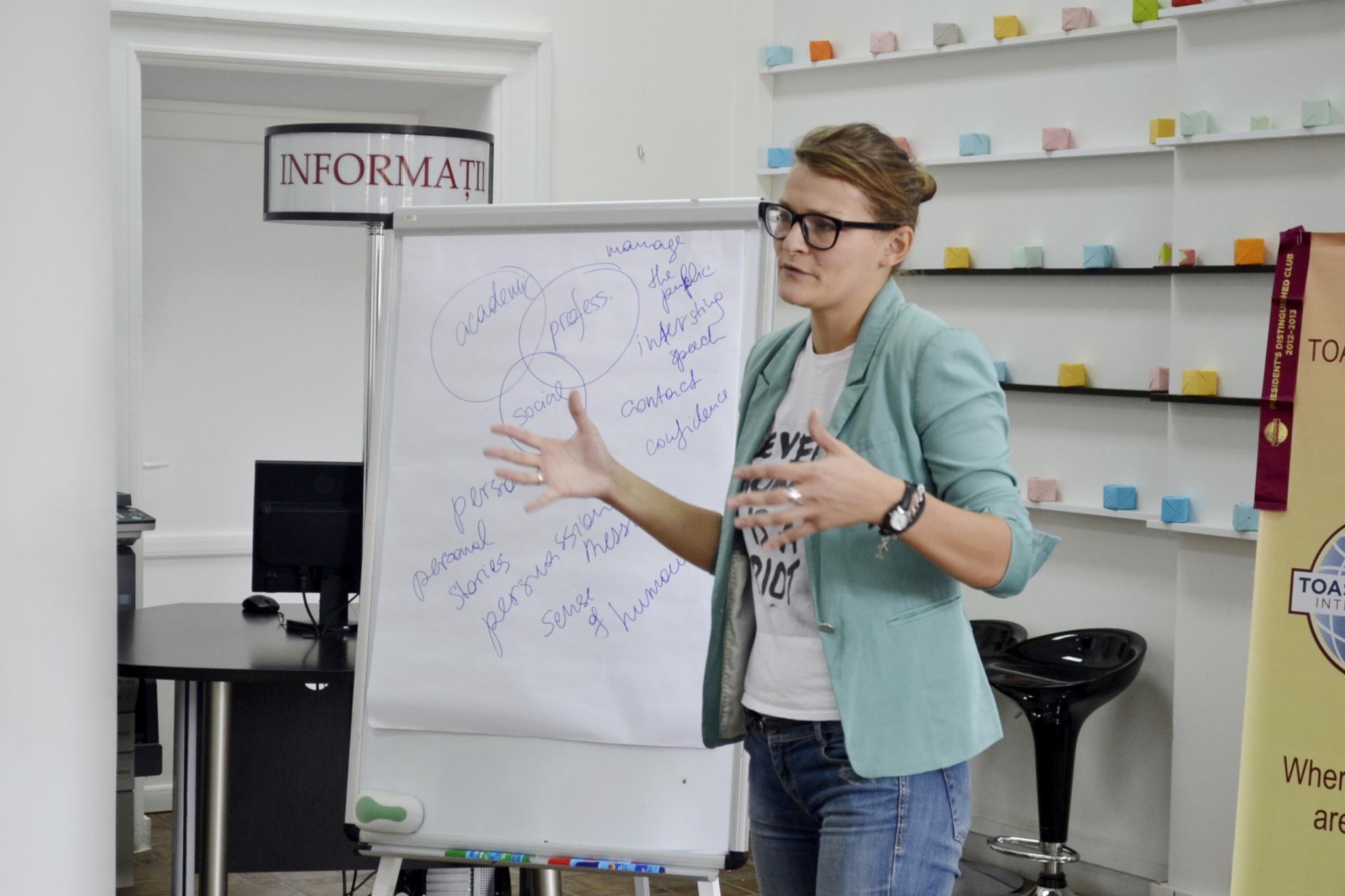 lady speaking standing next to a flip chart