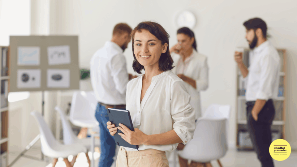 Woman standing in front of people holding blue book