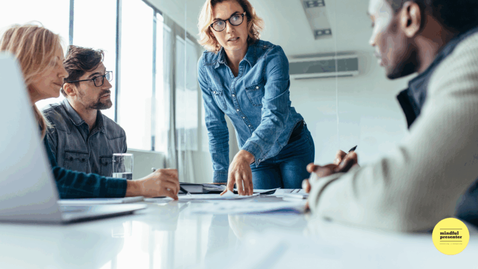 A meeting with a woman standing over the table