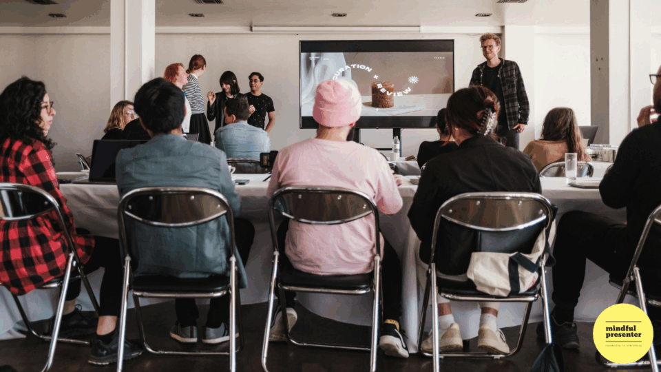 Man presenting to a group of people sitting around a table