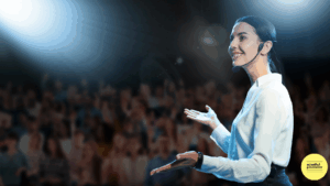 Woman speaking on stage with palms facing open and upwards