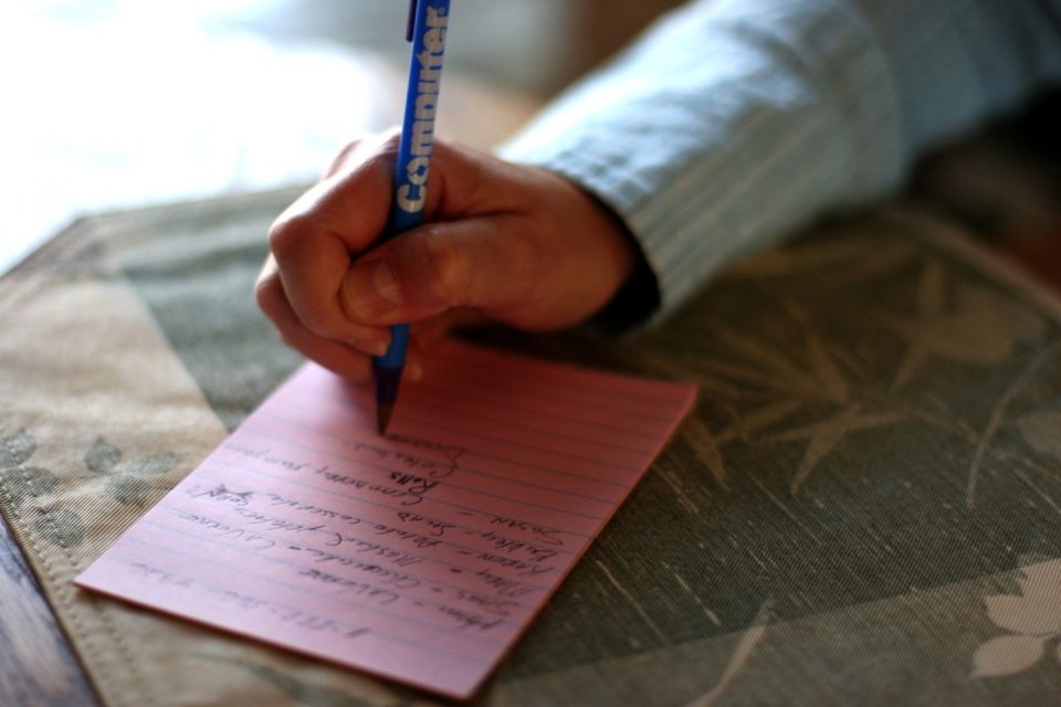 man writing on notepad