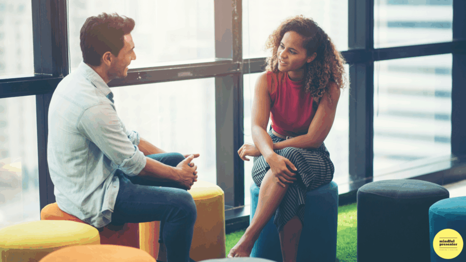 man and woman sitting on stools talking