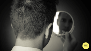 Black and white image of a man looking into a small mirror