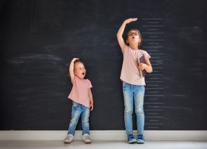 Two girls measuring their height