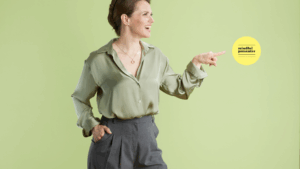 woman in green top pointing to mindful presenter log