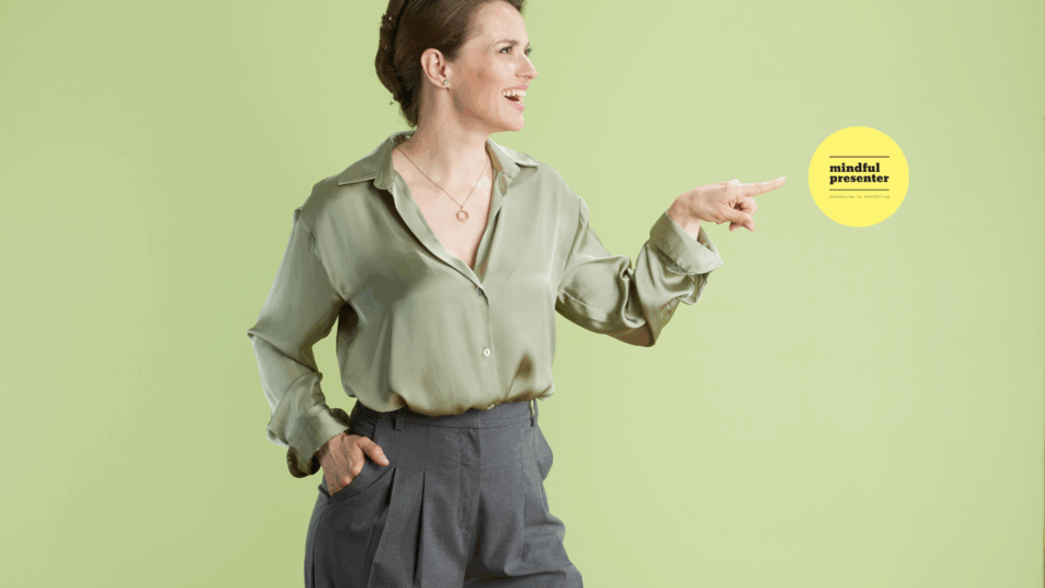 woman in green top pointing to mindful presenter log