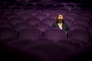 a woman sitting in the theater - she looks up - selctive focus on women