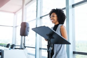 woman presenting standing next to lectern