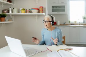woman wearing glasses and headphones using laptop