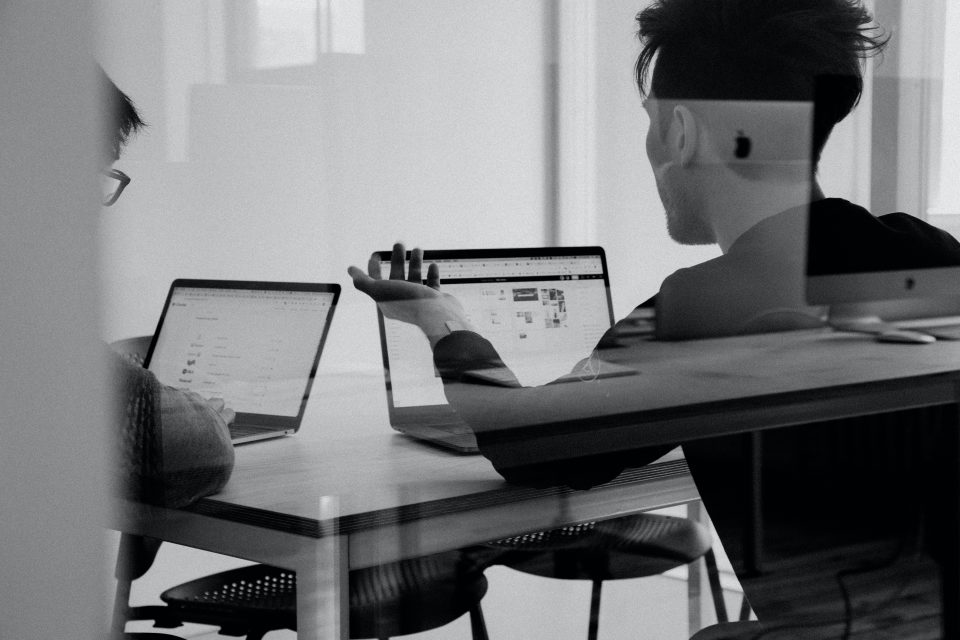 black and white image of man on laptop