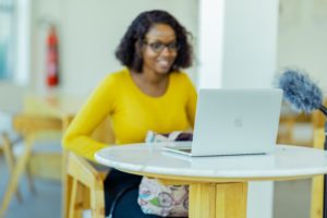 woman with yellow jumper on laptop