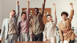 5 people smiling punching the air