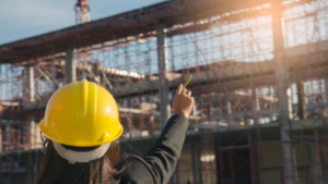 construction worker with hard hat point at site