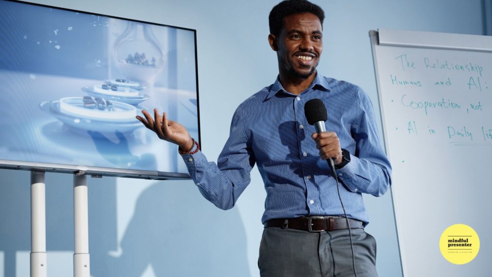 man presenting, speaking into a microphone