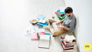 Man sitting on floor with books