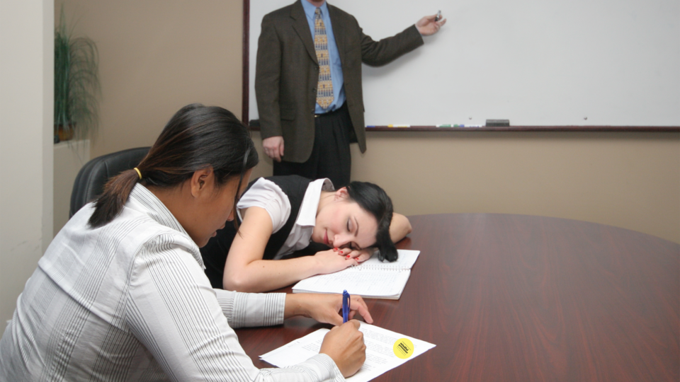 Two people bored in meeting