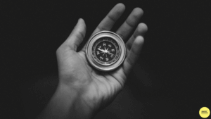 compass in a persons hand on black background
