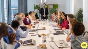 team meeting with man standing at head of table