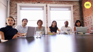 people with laptops open in meeting room
